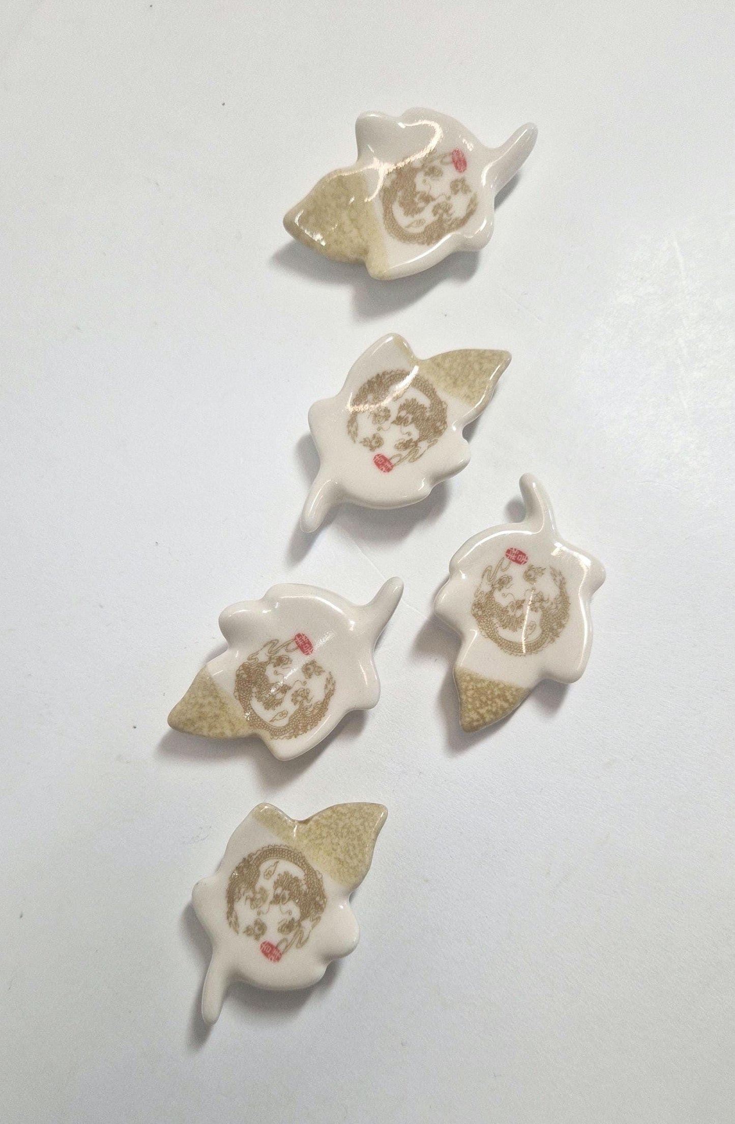 5 Chopstick Holders, Leaf Shaped with Dragon Design in Cream and Beige.